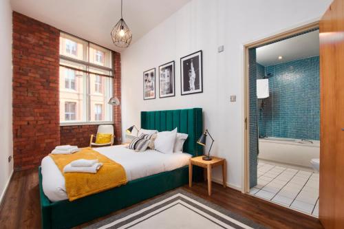 a bedroom with a bed and a bathroom with a tub at Lovely flat in central Manchester in Manchester