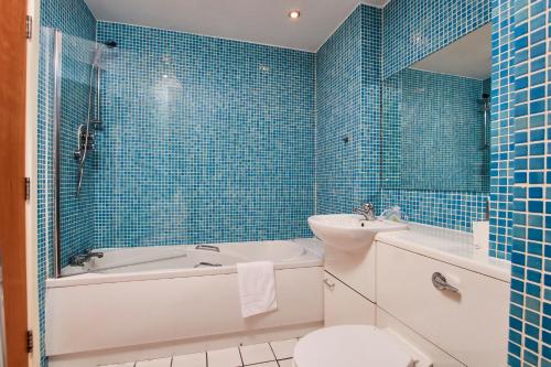y baño con bañera, aseo y lavamanos. en Lovely flat in central Manchester, en Mánchester