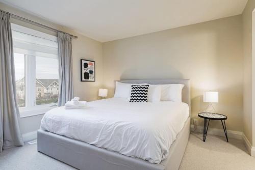 a bedroom with a large white bed and a window at Steps to Blue Mtn Condo wt Elegant Style 213 Sierra Lane in Blue Mountains
