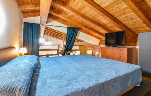 una camera con letto blu e TV di Stunning Home In Castiglione Di S With Wifi And 2 Bedrooms a Solicchiata