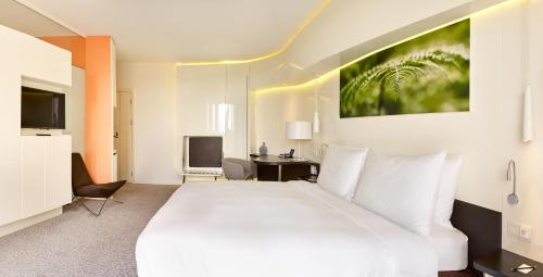 a bedroom with a large white bed and a desk at Radisson Blu Hotel & Convention Centre Kigali in Kigali