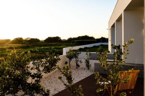 a garden with a wooden bench and plants on a building at Marinhas Bed & Breakfast in Esposende