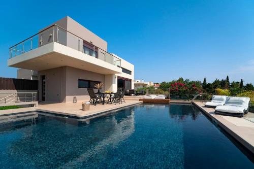 una casa con piscina frente a una casa en Ethereum Villa, en Asgourou