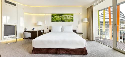 a bedroom with a large white bed and a desk at Radisson Blu Hotel & Convention Centre Kigali in Kigali