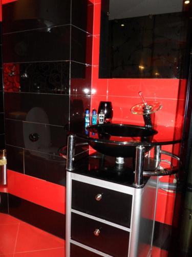 a bathroom with a black sink and a red wall at Casa De Cristal in Sofia