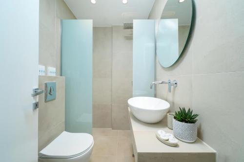 a bathroom with a sink and a toilet and a mirror at Sentimento Sea Breeze in Skala Prinou