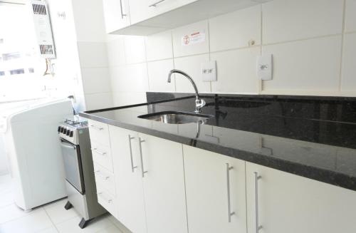 a white kitchen with a sink and a dishwasher at Rio Parque in Rio de Janeiro