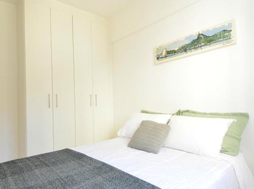 Un dormitorio con una cama blanca con una foto en la pared en Rio Parque, en Río de Janeiro