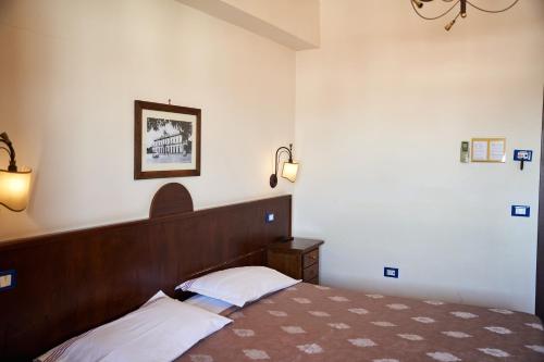 a bedroom with a bed with a wooden head board at Hotel Max in Aversa