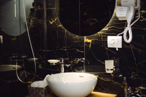 a bathroom with a sink and a mirror at Duplex Rooms in Korçë