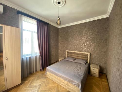 a bedroom with a bed and a large window at HovSer in Yerevan