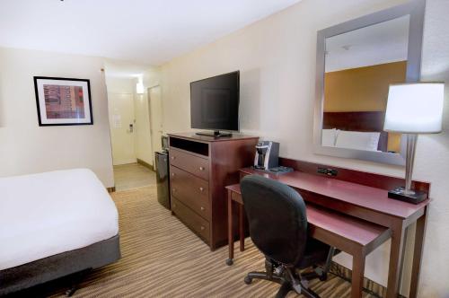 a hotel room with a desk and a bed and a bed and a room with at Holiday Inn St. Petersburg N - Clearwater by IHG in Clearwater
