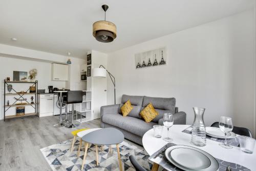 un salon avec un canapé et une table dans l'établissement Chic studio near Paris - La Defense, à Bezons