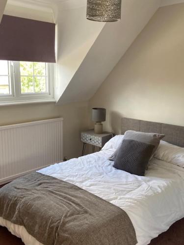 een slaapkamer met een wit bed en een raam bij 37 The Street, Weeley, Clacton on Sea, Essex CO16 9JD in Weeley