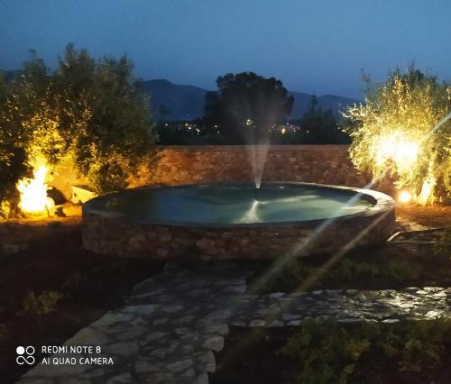 a fountain in a yard at night with lights at Villa in the Olive Trees in Galaxidi