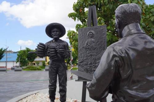 a statue of a boy standing next to a statue at Casa Libertad in Cayey