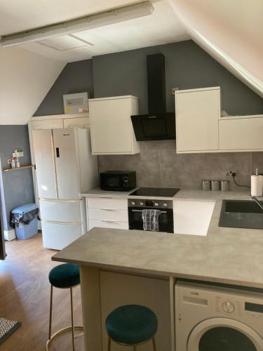 a kitchen with white cabinets and green stools at Segais Accommodation in Grove
