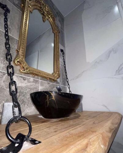 - une salle de bains avec un bol noir sur un comptoir avec un miroir dans l'établissement Medusa spa 34, à Montpellier