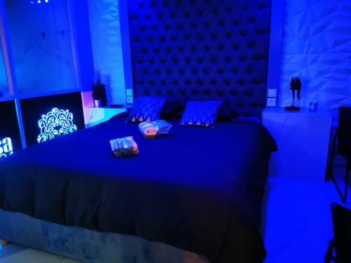 1 dormitorio azul con 1 cama grande con almohadas azules en Medusa spa 34, en Montpellier