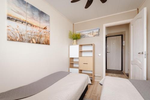 a bedroom with two beds and a painting on the wall at Kuuse 4 Apartment with 2 bedrooms in Haapsalu
