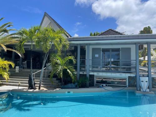 uma casa com piscina em frente a uma casa em Résidence Adam et Eve em Orient Bay