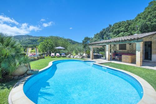 a swimming pool in a yard with a house at Owl Booking Villa Can Demana - Retreat in the Midst of Nature in Pollença