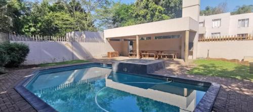 a swimming pool in front of a house at HomeSweetHome City Apartment in Nelspruit