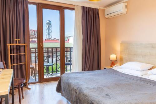 a hotel room with a bed and a balcony at Hotel N16 in Batumi