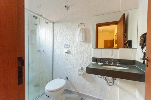 y baño con aseo, lavabo y ducha. en Hotel Imperium Village, en Sarapuí