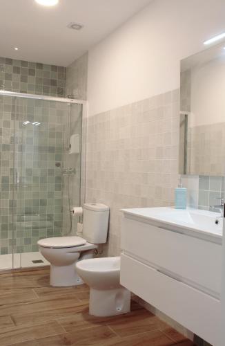 a bathroom with a toilet and a sink and a shower at Apartamento Altair-Éter in Soportújar