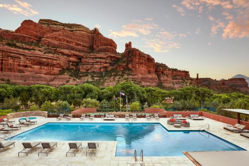 a pool with chairs and a mountain in the background at Enchantment Resort in Sedona