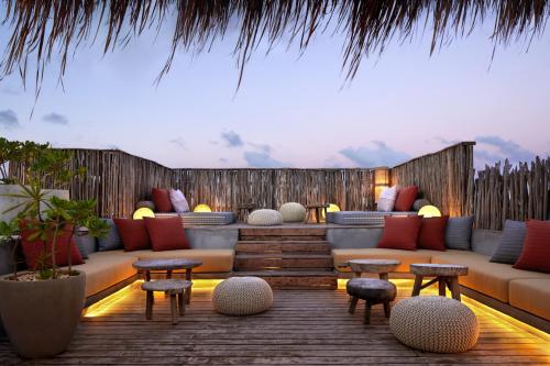a living room filled with furniture and tables at Kimpton Aluna Resort Tulum, an IHG Hotel in Tulum