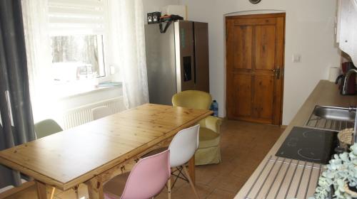 a kitchen with a wooden table and chairs and a refrigerator at Fantazja Góra Św Anny in Góra Świętej Anny