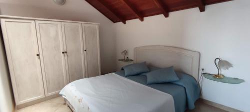a bedroom with a bed with two blue pillows at Penthouse with Terrace in Santa Maria Ca Firenze Sal Service in Santa Maria