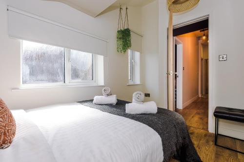 1 dormitorio con 1 cama blanca grande y 2 toallas en Four Bedroom Urban Home hosted by MCR Dens, en Mánchester