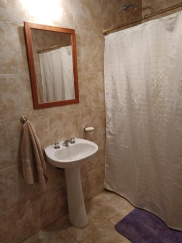 y baño con lavabo y ducha con espejo. en La Paz en Lobos