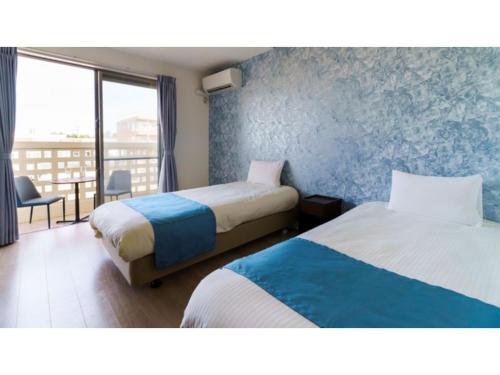 a hotel room with two beds and a balcony at Bears Stay Kumejima Eef Beach - Vacation STAY 85666v in Kumejima