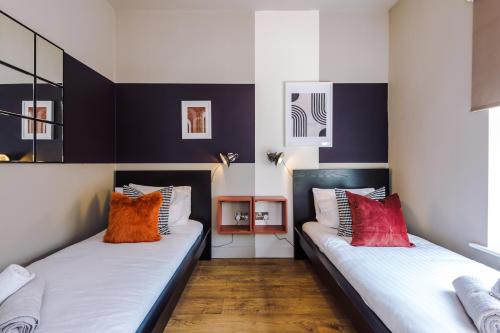 dwa łóżka w pokoju z czarno-białym w obiekcie Four Bedroom Urban Home hosted by MCR Dens w Manchesterze