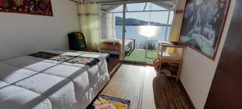 a bedroom with a bed and a view of the water at Uros Amaru Marka Lodge in Uros