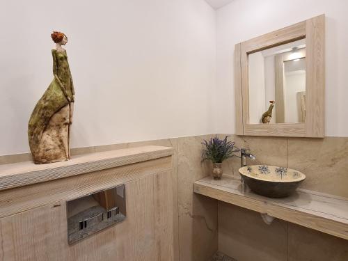 łazienka z umywalką i pomnikiem na ladzie w obiekcie Gościniec Iłżanka w mieście Iłża