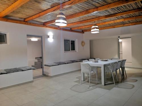 a dining room with a table and chairs and a couch at Chrysanthi Villa, Living in Nature in vlicha