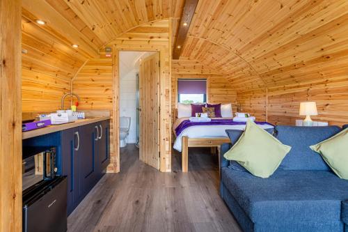 a log cabin with a bed and a couch at Kings Caves Glamping in Torbeg