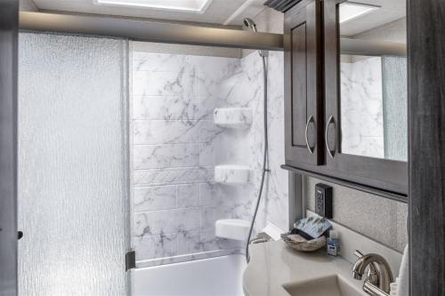 biała łazienka z prysznicem i umywalką w obiekcie H - Driftwood w mieście Fort Bragg
