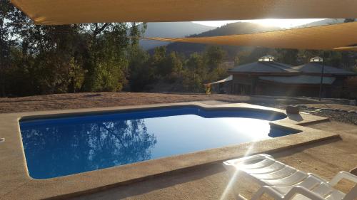 een zwembad met stoelen naast een huis bij Las Palmas Lodge in Olmué