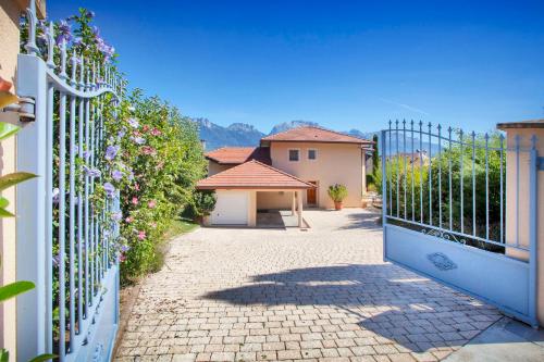 a gate to a house with flowers on a fence at Le Mas de Sevrier in Sévrier