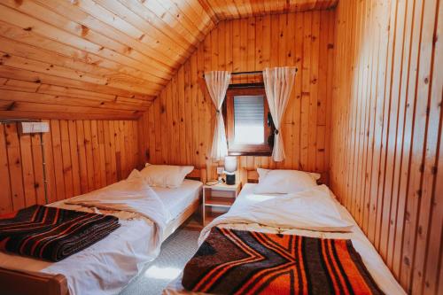 a bedroom with two beds in a wooden cabin at Momo's House in Žabljak