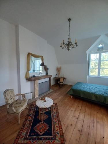 une chambre avec un lit, une table et un miroir dans l'établissement Château du Roc, à Saint-Thomas-de-Cônac