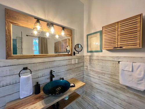 a bathroom with a sink and a mirror at Treetops Hotel in Caye Caulker