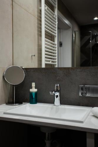 a bathroom sink with a bottle of soap on it at LuxuryCity Apartment with Terrace in Wrocław