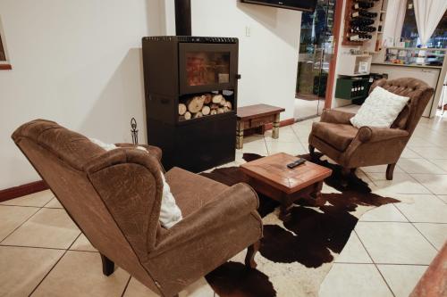 a living room with two chairs and a tv at Rodeio Hotel in Rodeio Bonito